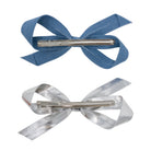Bow Clip Set of two: one light blue denim and one shiny silver, both with visible metal alligator clips on the back.