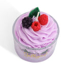 Cupcake-shaped candle with purple frosting and berry decorations on a white background