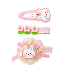 Three hair clips: pink bunny on pink fabric, three pink flowers with green leaves on pink ribbon, white bunny on crochet with pink ribbon.