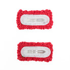Two red crocheted hair clips.

