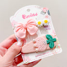 Three hair clips on a decorative card: pink bow, white daisies, and a pink embroidered design with green leaves and pearls.

