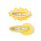 Two yellow fabric hair clips.
