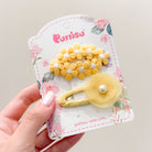 Yellow flower hair clips on floral card.
