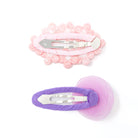 Two hair clips, one pink and one purple, on white.