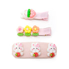 Three children's hair clips: strawberry-rabbit, three flowers, and three rabbits with strawberries. All clips are pink.