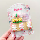 Package of children's hair clips featuring flower, rabbit, and strawberry themes.

