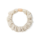 Beige fabric hair tie with wooden toggle.
