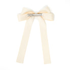 Ivory ribbon bow hair clip on a white background.
