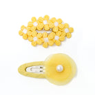 Two yellow flower hair clips.
