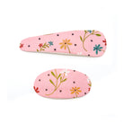 Two floral patterned hair clips, one oblong and one oval, on a white background.