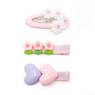 Three hair clips with pink and white accents.