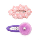 Two hair clips with fabric flowers. One is pink daisy-like flowers; the other is a purple fabric flower with a pearl accent.