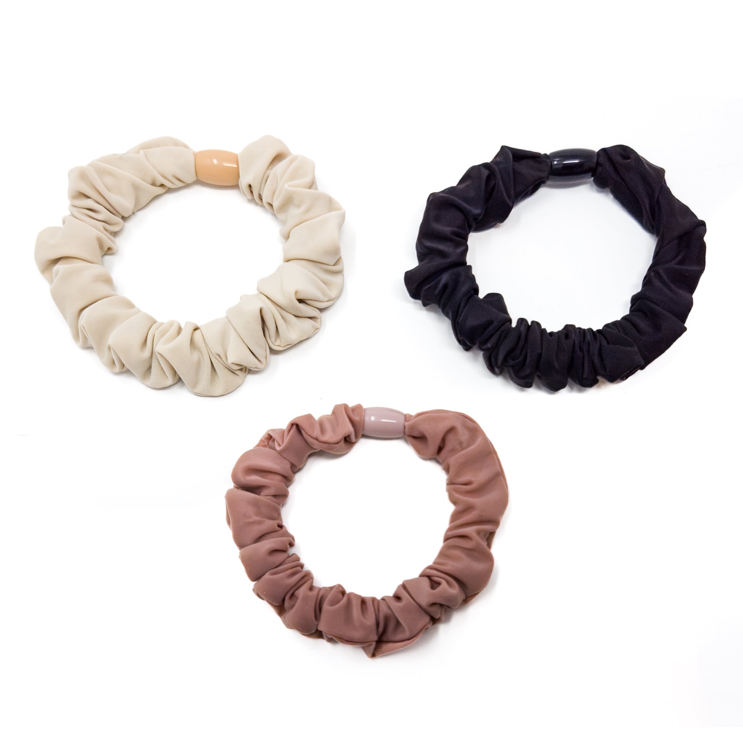 Three fabric-covered elastic hair ties. Beige, black, and brown.