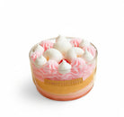 Cupcake in a glass with pink frosting and white meringues on a white background