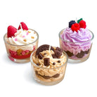 Three small dessert cups with different flavors and toppings on a white background