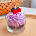 Purple frosted cupcake with berries in a glass on a wooden surface