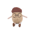Stuffed brown toy bean with glasses and a hat sitting.