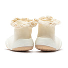 Two cream-colored sock shoes with ruffled tops.
